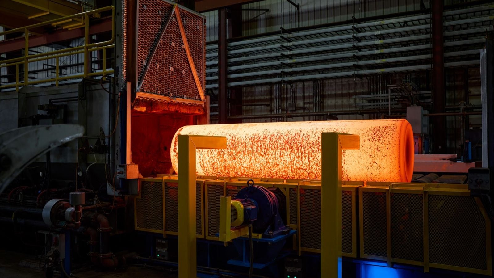 A glowing yellow tube of hot titanium moves through a Perryman Company foundry.